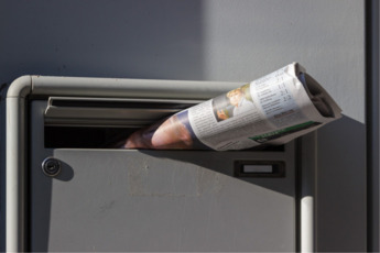 Dekoratives Bild von einem Briefkasten mit Post