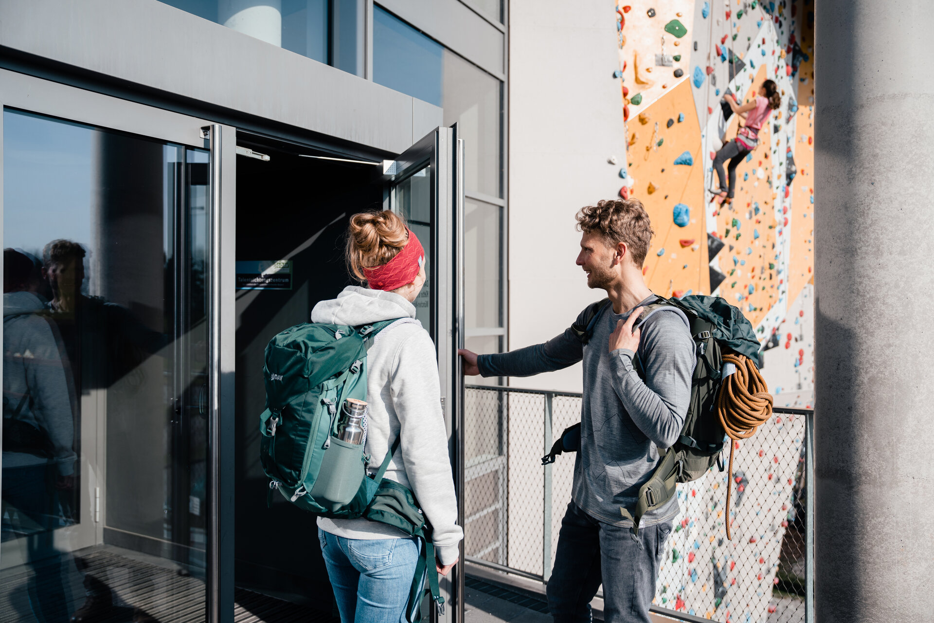 Bouldern und Indoor-Klettern ist bei vielen DAV-Sektionen möglich | © DAV/Marisa Koch Zwei Persinen öffnen die Tür zu einer Boulder- und Kletterhalle | © DAV/Marisa Koch