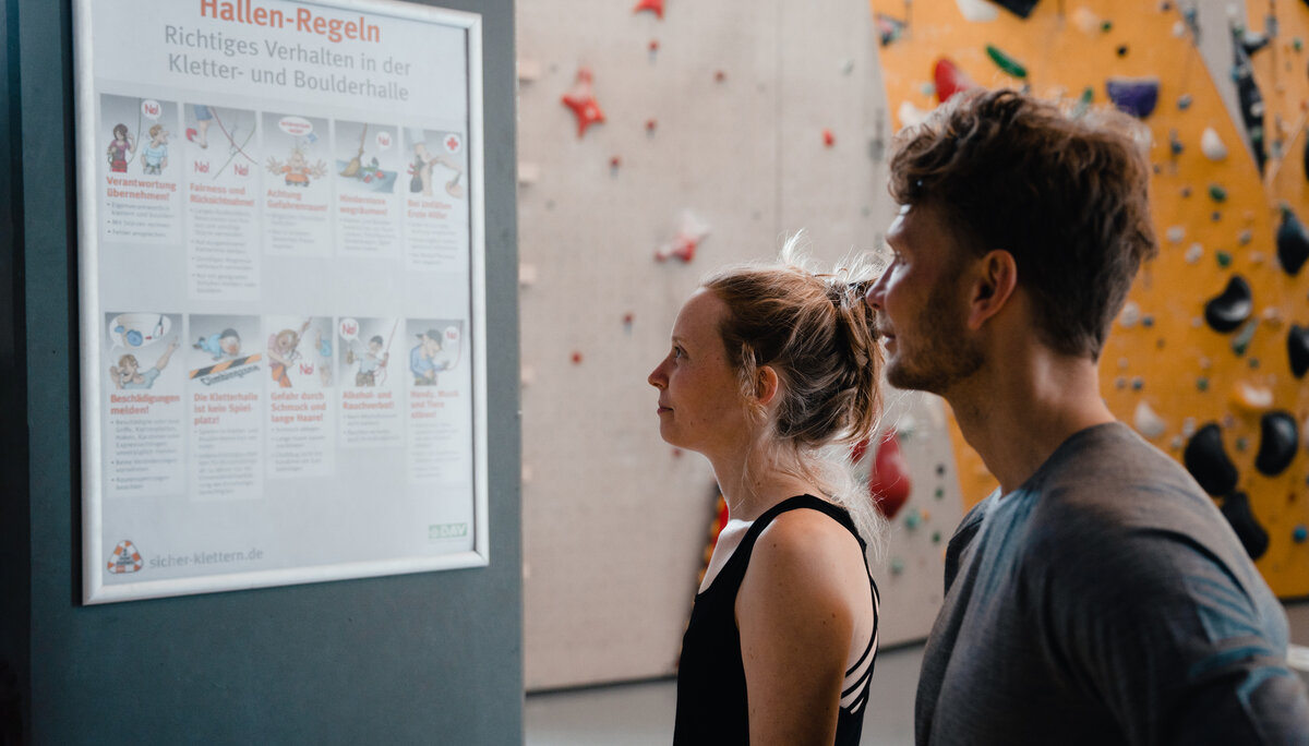 Boulder und Indoor-Klettern ist bei vielen DAV-Sektionen möglich | © DAV/Marisa Koch Zwei Personen checken den Trainingsplan, der an einer Wand hängt | © DAV/Marisa Koch