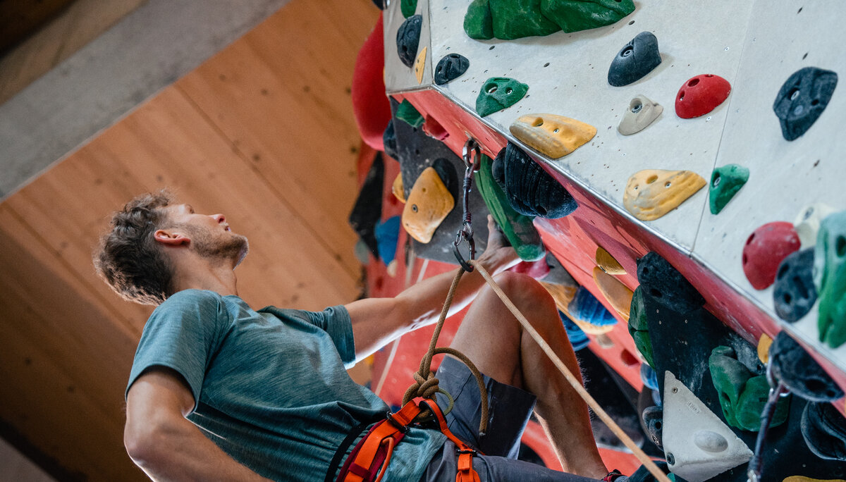Boulder und Indoor-Klettern ist bei vielen DAV-Sektionen möglich | © DAV/Marisa Koch Ein Mann beginnt an einer Wand zu bouldern | © DAV/Marisa Koch